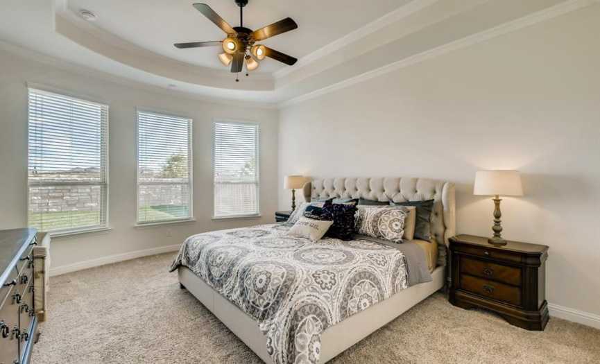 Lots of natural light and a ceiling fan make the primary bedroom comfortable