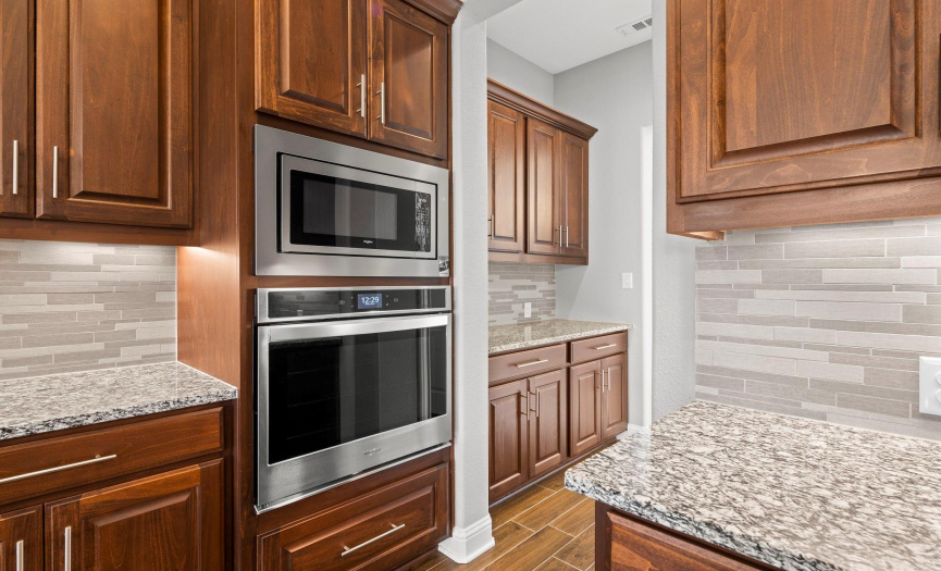 Stainless steel appliances. View of Bulters Pantry, with large walk-in pantry just across from it. 