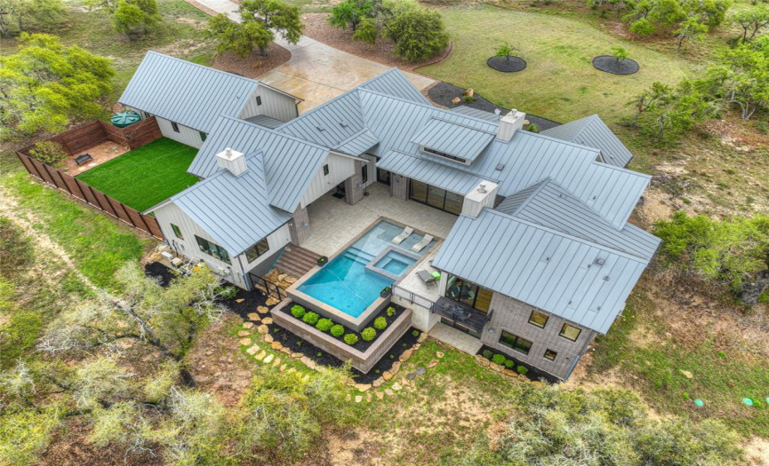 Aerial view of the home which includes the backyard and driveway leading to the home.
