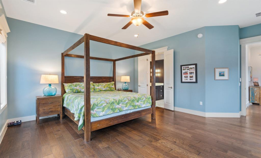 This spacious, light-filled primary bedroom offers everything you could want for a relaxing evening. The high ceiling and recessed lighting create a cozy atmosphere that invites you to read, sleep, or decompress in private