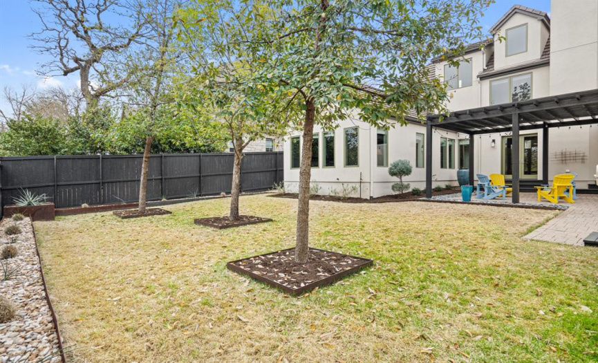 The backyard is beautifully landscaped with an expansive lawn perfect for playing games or entertaining guests outdoors