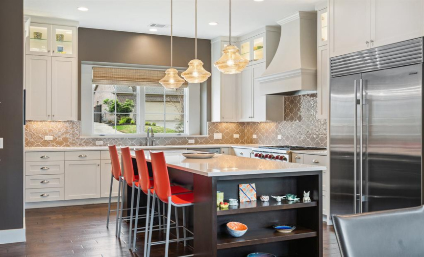 The gourmet kitchen is truly a chef's dream with quartz countertops, gorgeous shaker-style cabinetry, designer lighting and backsplash plus high-end SS appliances 