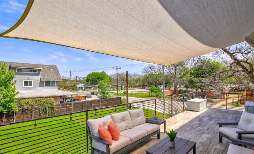 The upstairs patio overlooks a city lot.