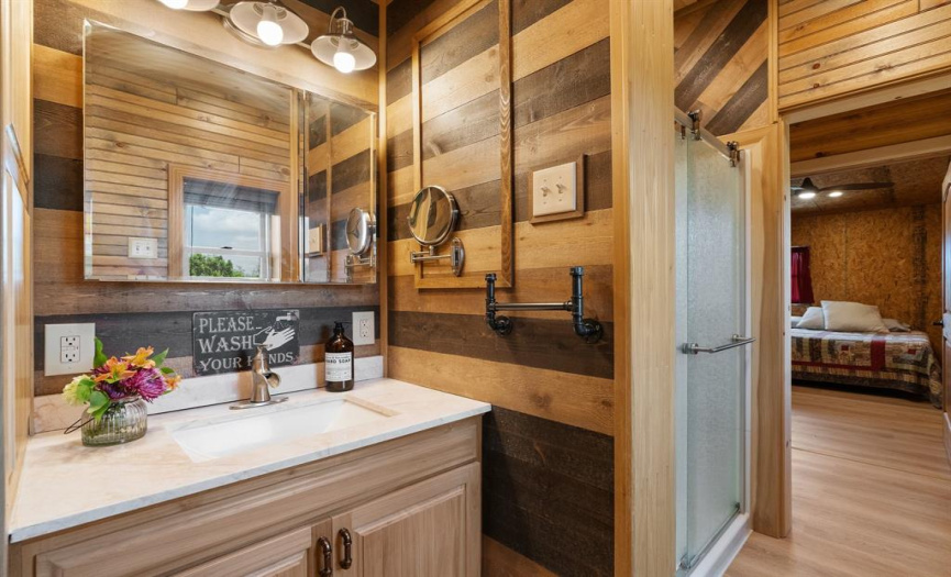 The full bathroom also offers a walk-in shower with a sliding glass door.