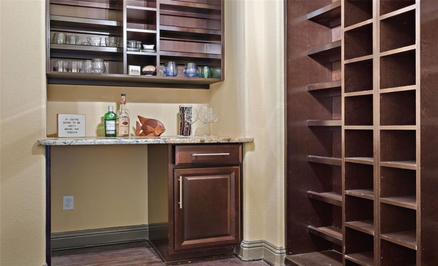 Wine room with granite countertop and great storage for wine/glasses and space for a fridge.
