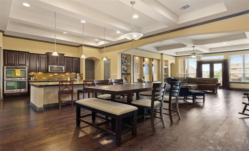 Open floor plan with kitchen, breakfast and family room. More custom ceiling treatments and decorative niches.