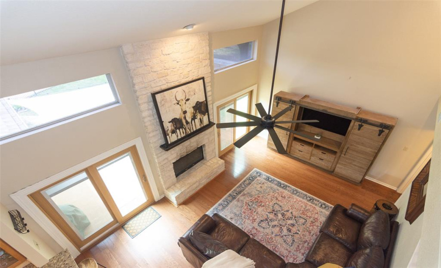 Looking down on family room, which features stone fireplace.