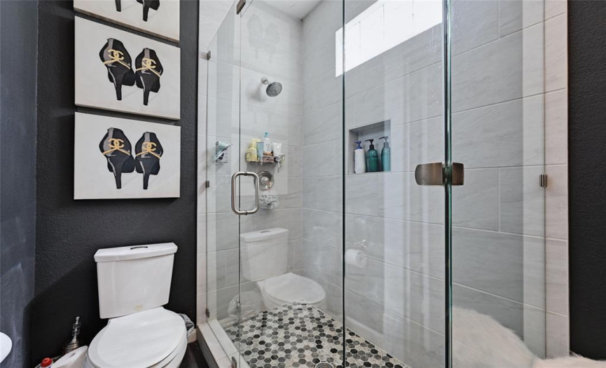 Step into the ensuite bathroom, with a beautiful walk-in shower and a vanity adorned with quartz counters.