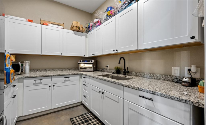 Kitchen has ample storage, granite counters, deep sink, and full size refrigerator