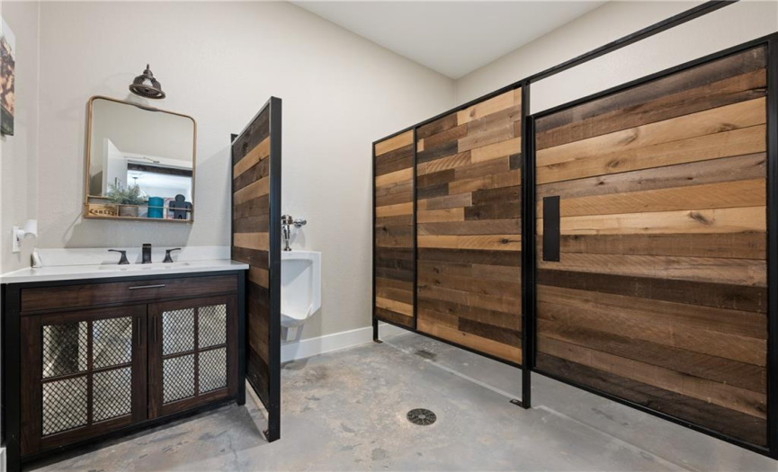 Completely remodeled men's restroom with private stall and urinal, plus vanity with storage