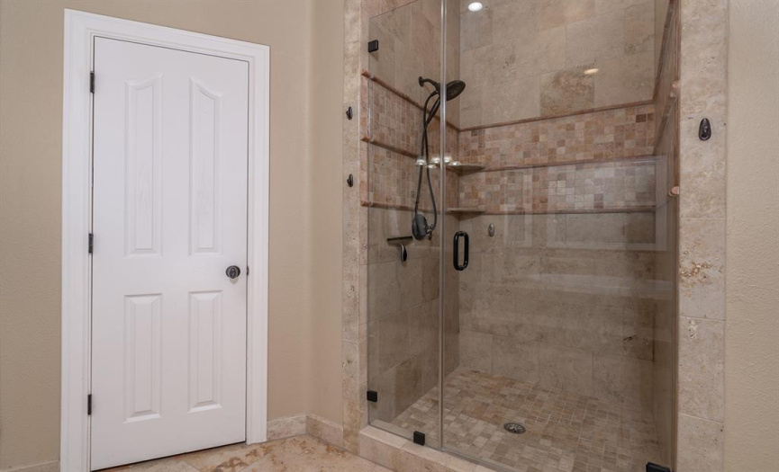 Primary Suite with Frameless Shower door and Travertine tile to the ceiling!