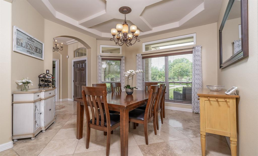 Formal Dining, Tray ceiling, Arched Doorways, Travertine Flooring, View to the front yard.