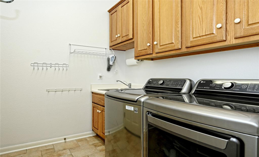 Laundry room with useful wash basin and upper cabinets.