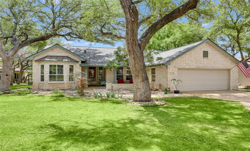 Mature Texas Live Oaks lovingly frame this limestone and stucco exterior home by Del Webb. Roof recently replaced in 2020!