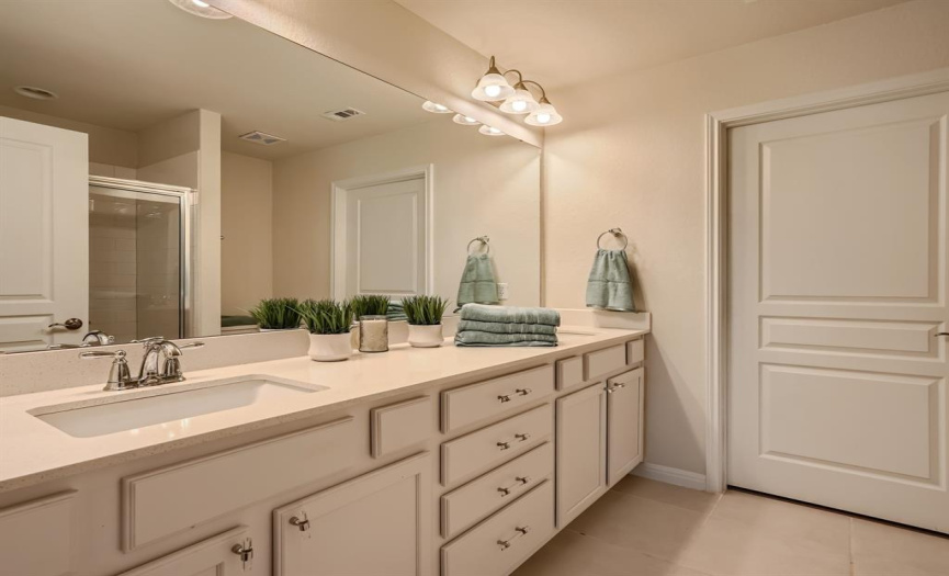 Dual sinks in the Master Bath with quarts and white cabinets. 