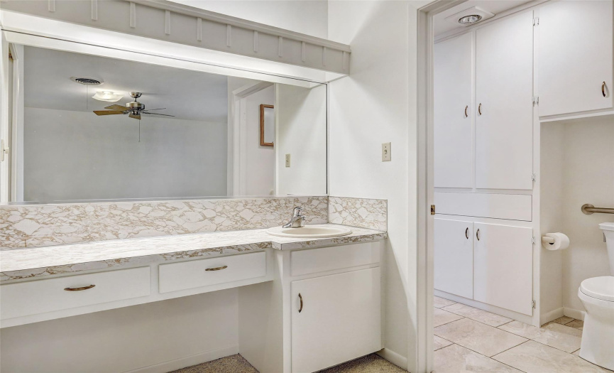 The primary bedroom's bathroom vanity has lots of room on the countertop for getting ready, including a mirror that covers the entire wall.