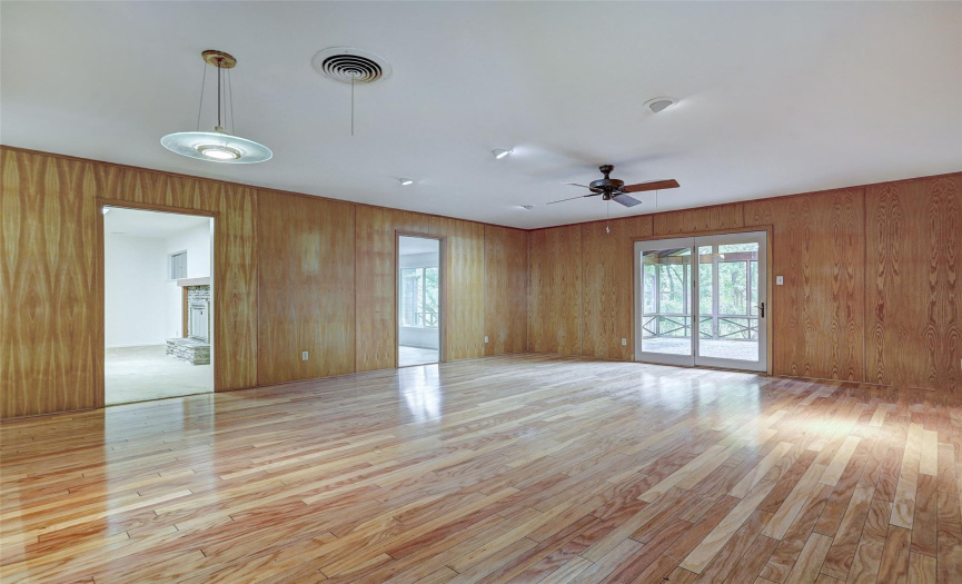 The expansive family room has gorgeous wood paneling and wood floors, creating a warm and inviting environment for everyday living or special celebrations. 