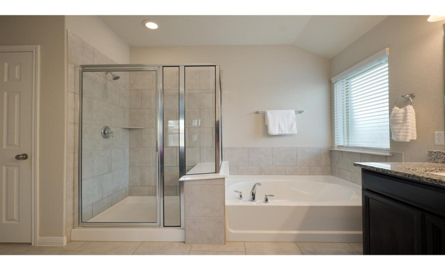 Primary bath has a garden tub and separate shower