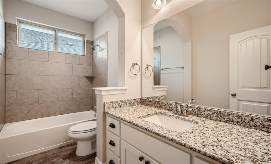 Full bathroom features granite counters and a tub/shower combo.