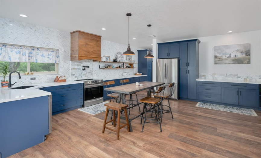 Stunning herring bone feathered tile backsplash, wood accent vent hook, quartz countertops and stainless steel appliances.  Also has second refrigerator hookup in the kitchen