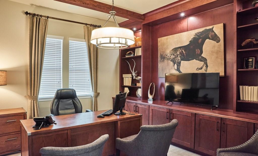 Beautiful study / office w/ custom built-in cabinetry and ceiling beam work.