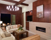 Cozy up by the rectangular gas fireplace, adorned with an elegant floor-to-ceiling tile surround.