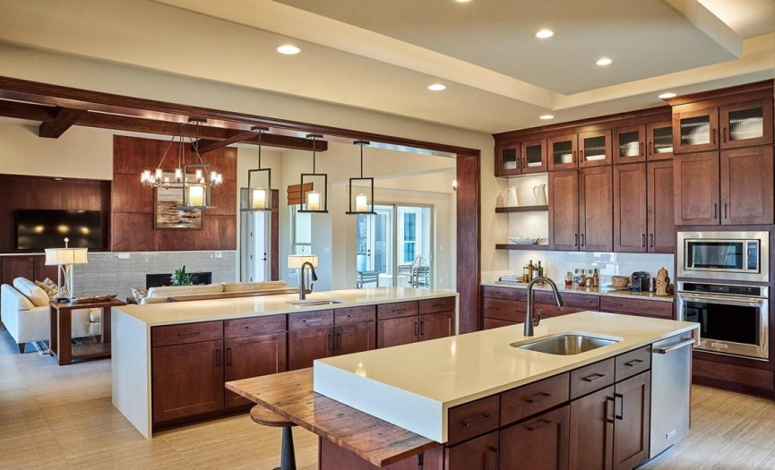 The heart of this home is the impressive kitchen. With two functional islands, upgraded appliances, a spacious walk-in pantry, and custom cabinets, this kitchen is a haven for culinary creativity. 
