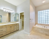 Primary bathroom has double vanities, custom cabinetry, a jetted tub and walk-in shower. 