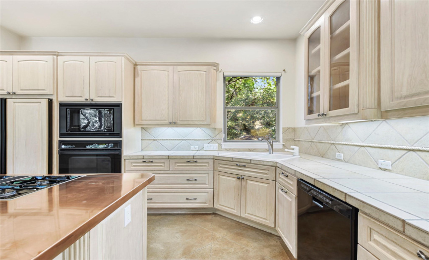 A chefs dream! Spacious kitchen features tons of custom cabinetry with pull-out shelving, built-in refrigerator, instant hot water dispenser, under mount lighting, gas cooktop and more!