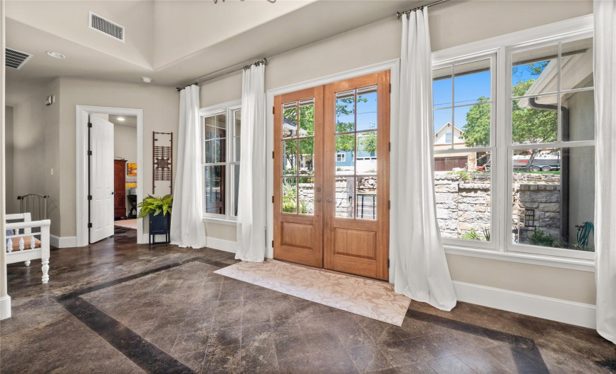 Step into your new home through a warm and inviting foyer that greets you with a flood of natural light from sunny windows. The moment you step inside, you'll be embraced by the sense of openness and serenity that the high ceilings bring to the space.