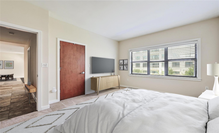 Indulge in the serene master bedroom featuring a ceiling fan, ample natural light from a large window, and en-suite bathroom.
