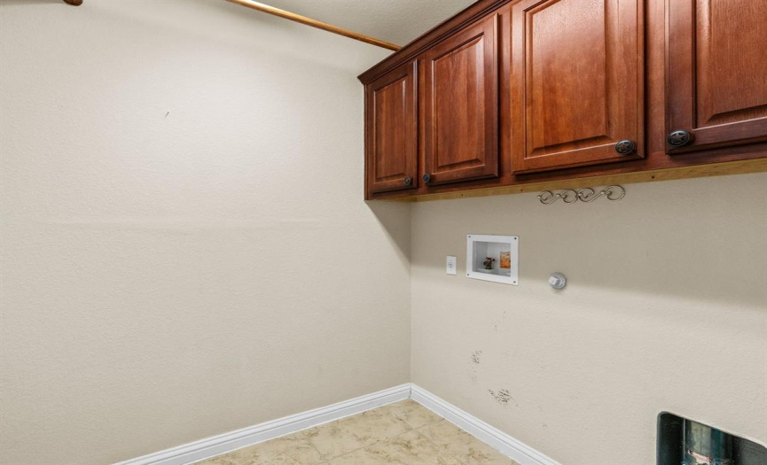 Laundry room with built-in cabinetry for additional storage space