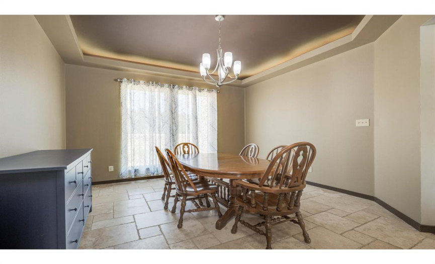 Dine in style in this beautiful formal dining room, with a custom lit ceiling and large window