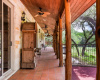 Classic Texas style as you look down the back porch with cedar pillars sourced from the property.