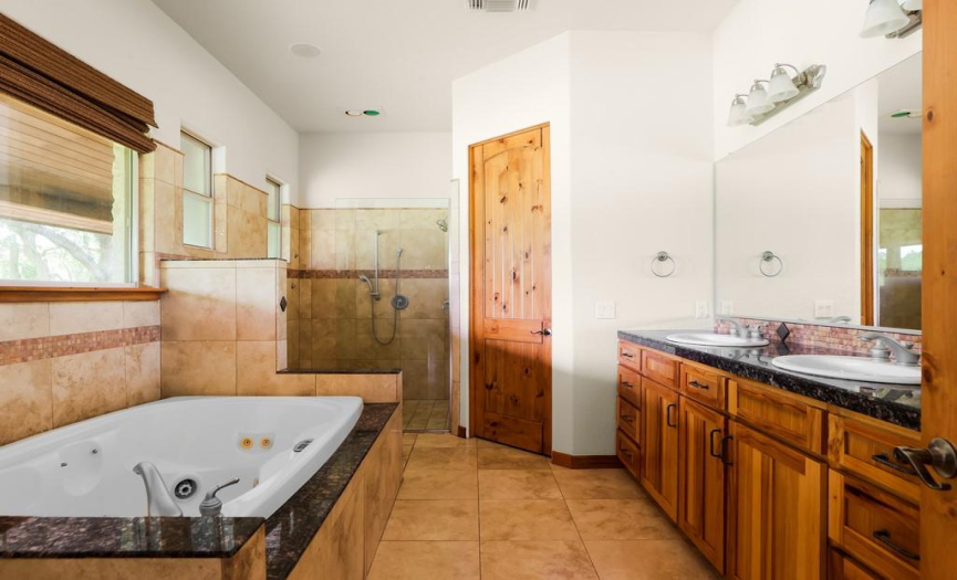 The primary bathroom in the Main House has a large jet tub and sprawling walk in closet.