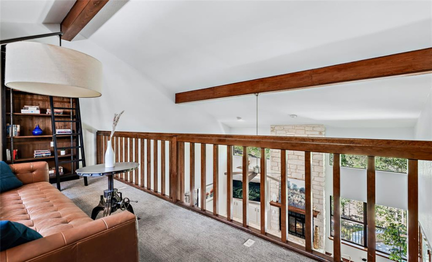 Railing of loft allows opening to the living room