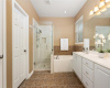Primary Bathroom with double vanity, garden tub, shower, private water closet & linen