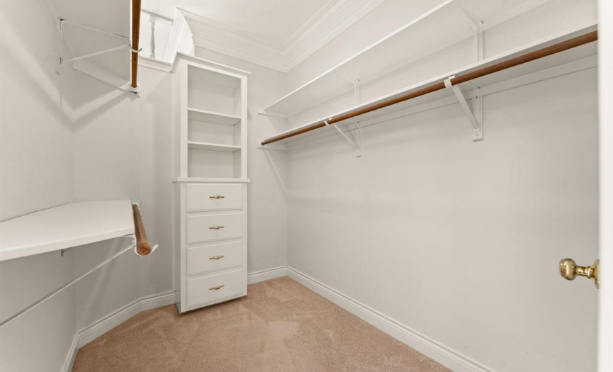 One of two identical primary closets holds lots of clothing, shoes, hats, etc.