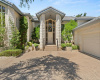 Regal home of white Austin stone has oversized 2 car garage with golf cart garage and air-conditioned workshop.