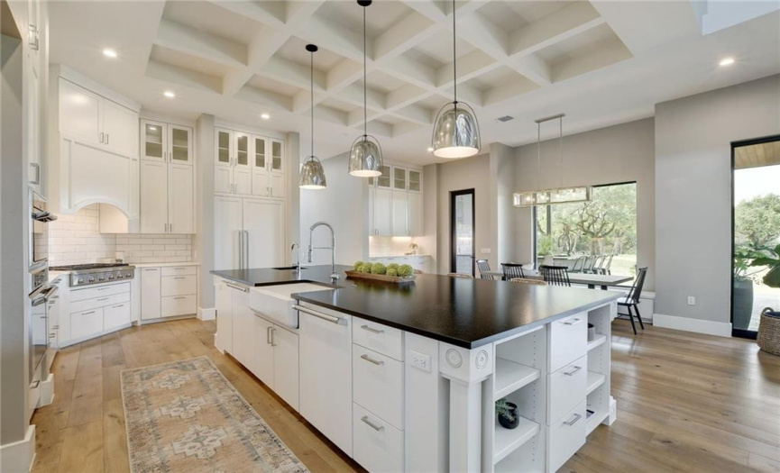 Large open kitchen serving the breakfast area with a beautiful view of the private backyard. Stunning black granite island 
