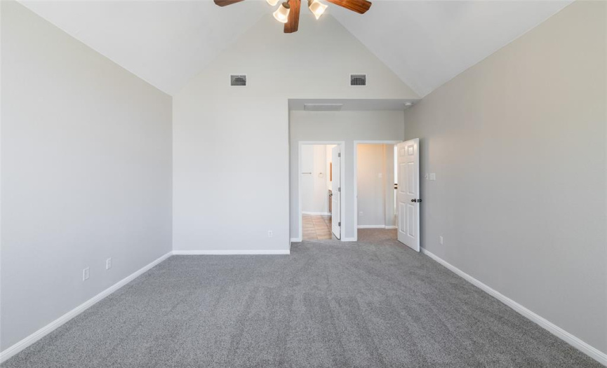 Master bedroom has a cathedral ceiling, built-in speakers, two-inch blinds, a ceiling fan with light fixture, a walk-in closet, and measures approximately 13 x 16.