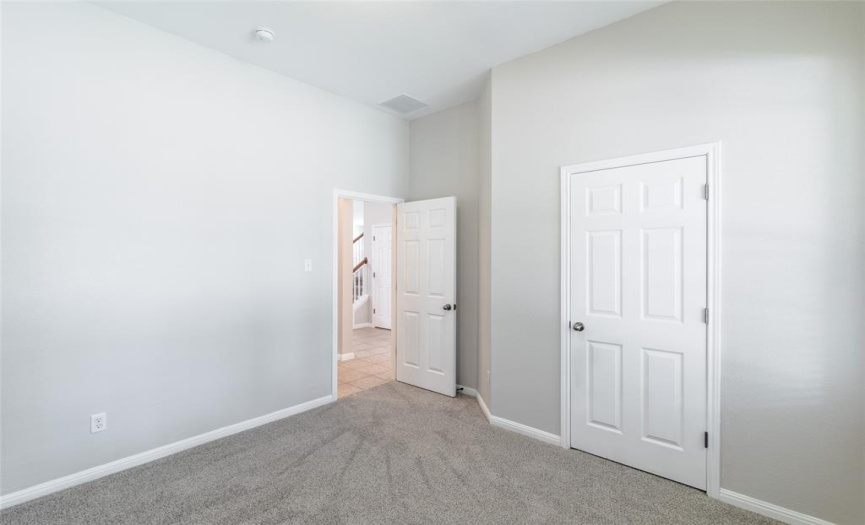 Bedroom 2 is on the main level and has two-inch blinds, a ceiling light, standard closet, an adjacent full bath, and measures approximately 10 x 11.