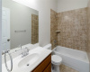 Bath 3 offers a vanity sink, tile flooring, and a standard shower / tub combo with tile surround.