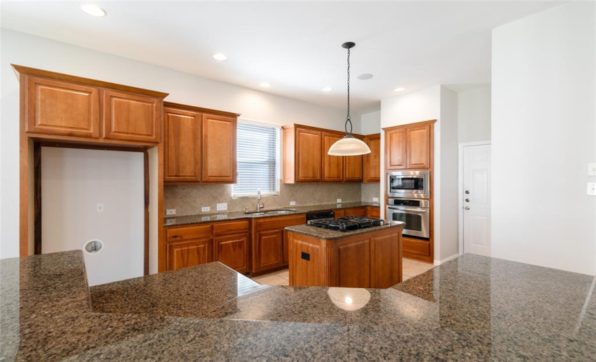 Island kitchen features granite counters, 42” cabinets, a breakfast bar, recessed lights, a pull-out faucet, a closet pantry, built-in speakers, and measures approximately 13 x 17.