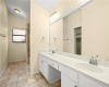 The primary bathroom is equipped with a large double vanity, ample storage space, and a make-up area.
