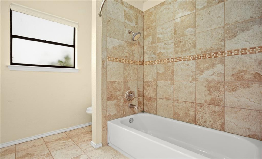 The primary bathroom also has a tub/shower combo with tile surround.