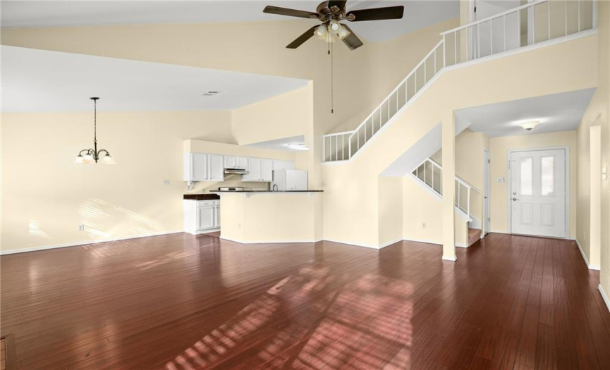 The entry opens to the spacious living room featuring gorgeous bamboo flooring and a soaring ceiling.