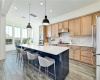 Pretty cabinets with quartz counters and eat at breakfast bar. Pendant lighting and stainless appliances.