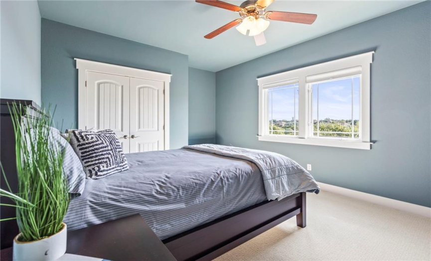 The second bedroom offers carpet flooring, a ceiling fan, and a generously sized closet.