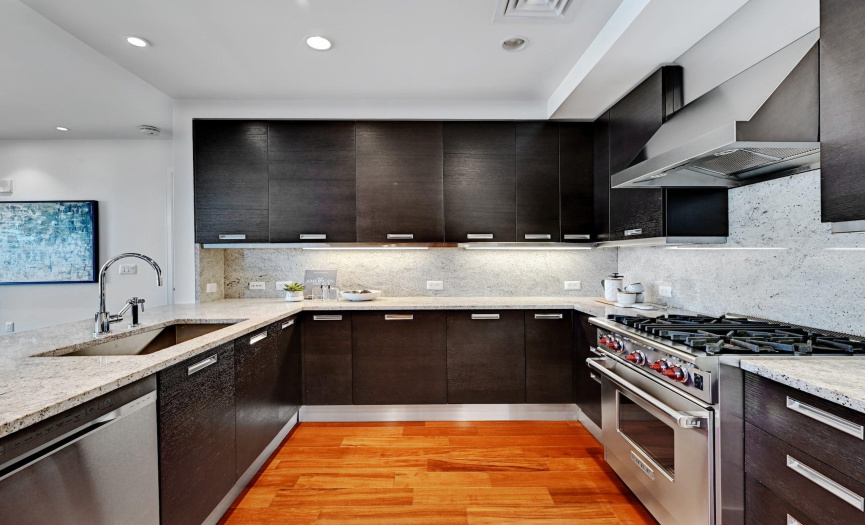 Undercabinet lighting illuminates the contemporary cabinetry, while the free-flowing layout ensures seamless entertaining